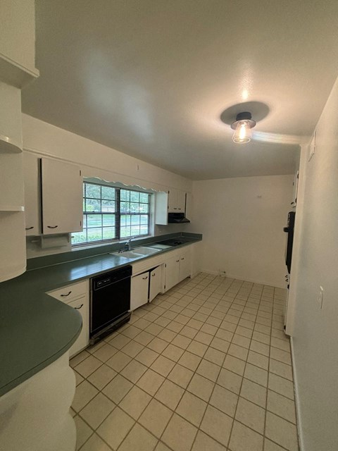 A kitchen with white cabinets and a black oven.