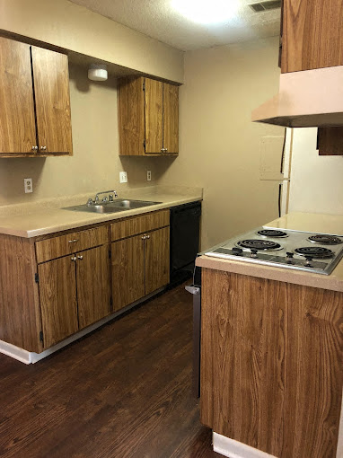 A kitchen with wooden cabinets and a stove top oven.