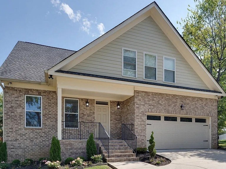 A house with a grey roof and a white garage door.