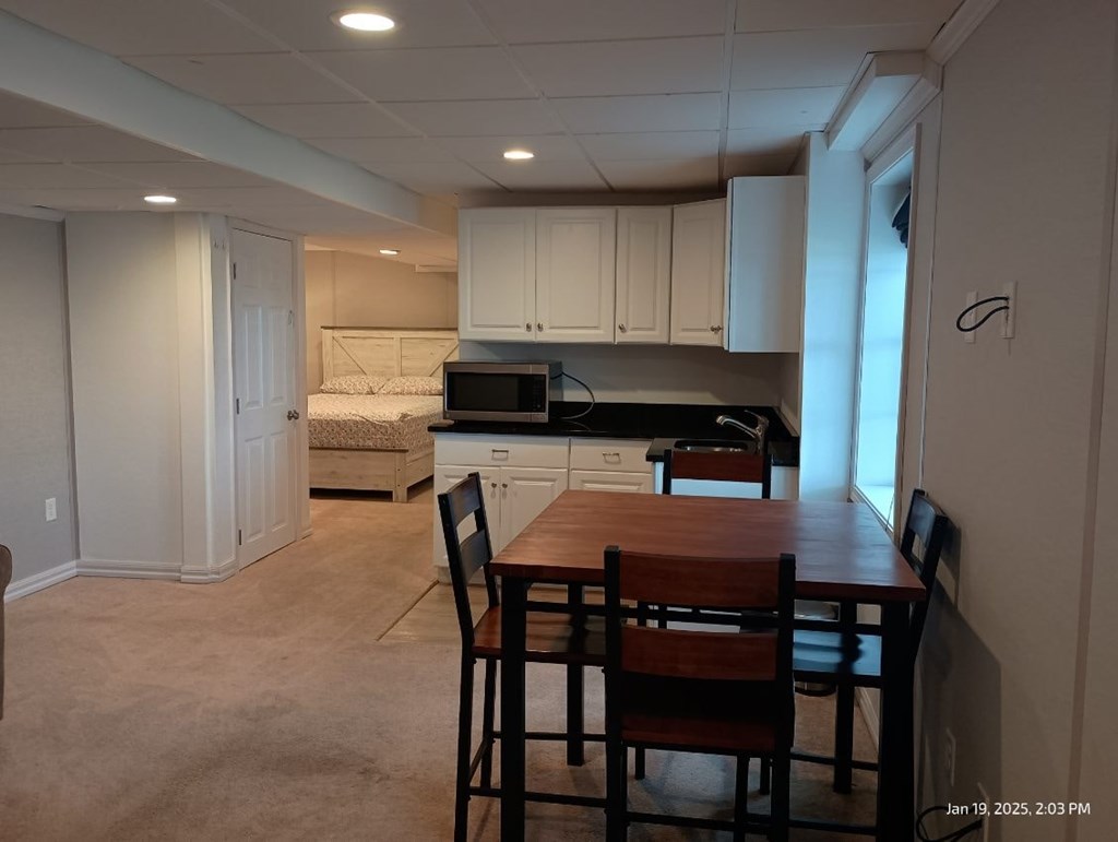 A kitchen with a table and chairs in the foreground.