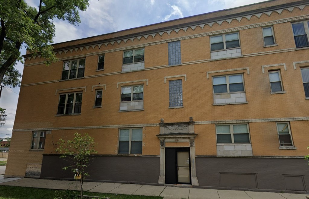 A brown building with a tree in front of it.