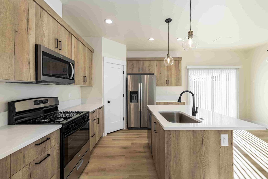 A kitchen with wooden cabinets and a stainless steel refrigerator.