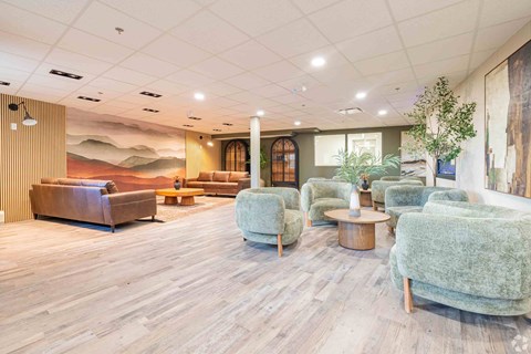 A living room with a wooden floor and a large mural on the wall.