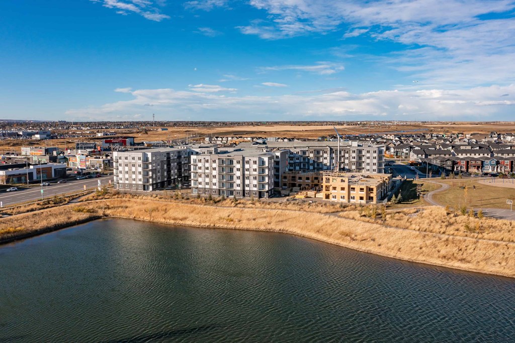 A large body of water is in the foreground of a cityscape with buildings in the background.