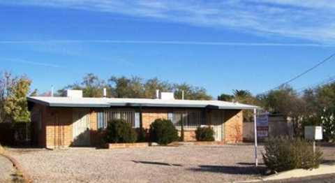 A house with a gravel driveway in front.