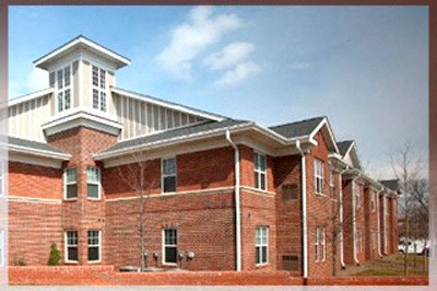 A red brick building with a white cupola on top.
