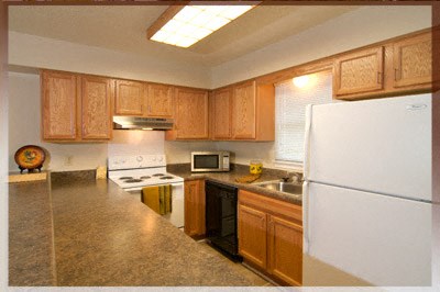 A kitchen with wooden cabinets and a white refrigerator.