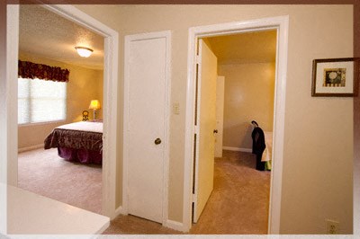 A man is standing in a hallway with a white door.