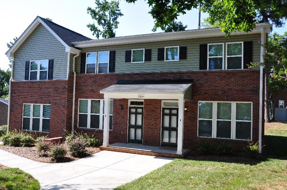 A two-story house with a brick facade and a grey roof.
