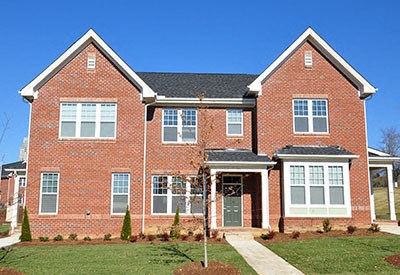 A red brick house with a black roof and white trim.