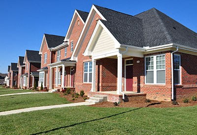 A row of houses with red brick and white trim.