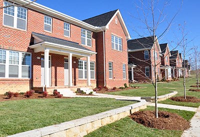 A red brick house with a white door and windows.