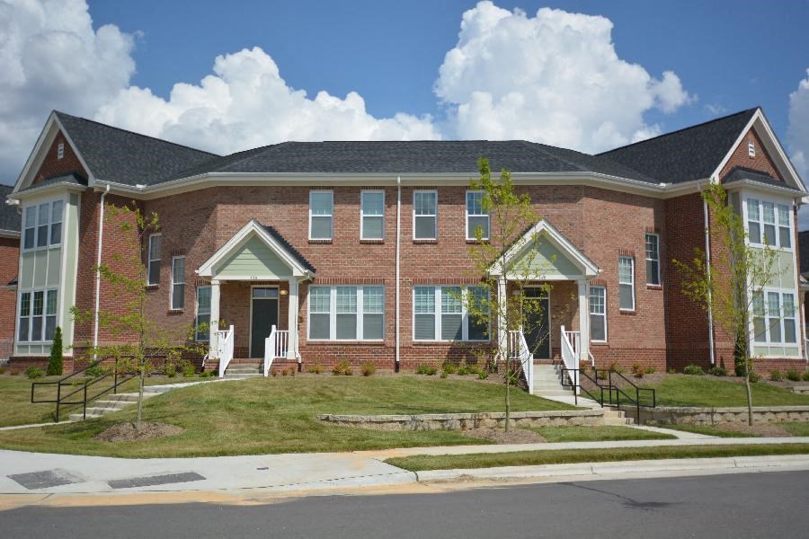 A red brick house with a white door and windows.