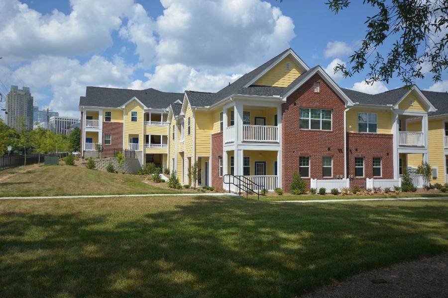 A row of houses with a city skyline in the background.