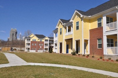 A yellow building with a white balcony is in the foreground.