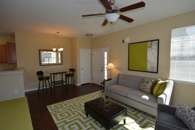 A living room with a couch, a coffee table, and a ceiling fan.