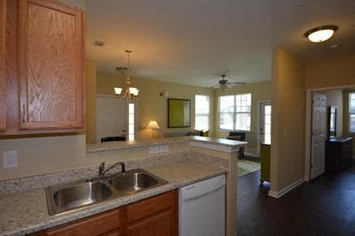 A kitchen with wooden cabinets and a white dishwasher.
