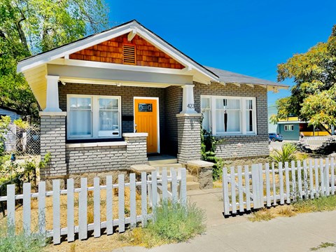 A house with a white picket fence in front.