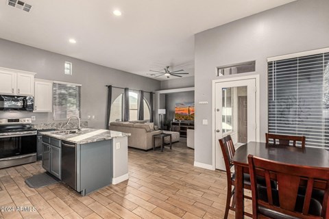 A kitchen with a dining table and chairs.
