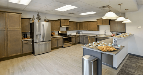 A kitchen with wooden cabinets and a stainless steel refrigerator.