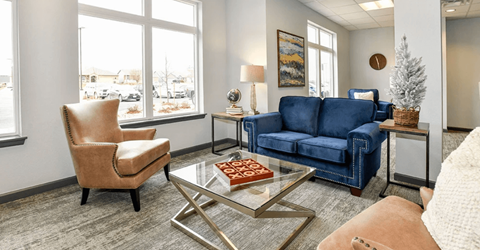 A living room with a blue couch, a chair, and a coffee table.