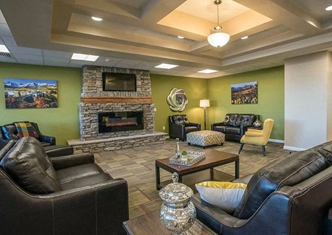A living room with a stone fireplace and a green wall.