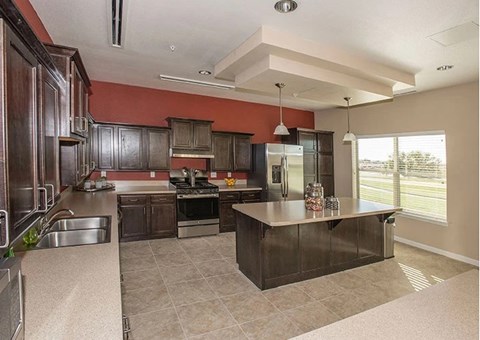 A kitchen with a large island and stainless steel appliances.