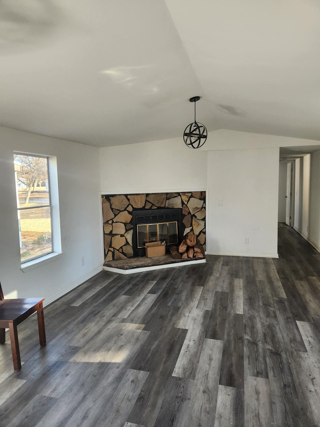 A room with a fireplace and wood flooring.