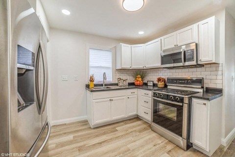 A kitchen with white cabinets and stainless steel appliances.