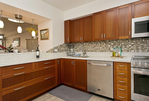 A kitchen with wooden cabinets and a tile backsplash.