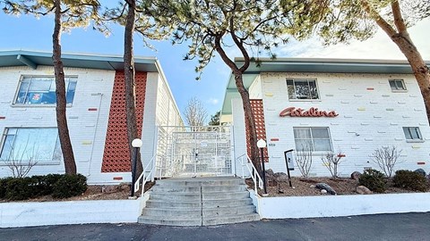 A white building with a red brick pattern on the side and a sign that says "Astoria" on the front.