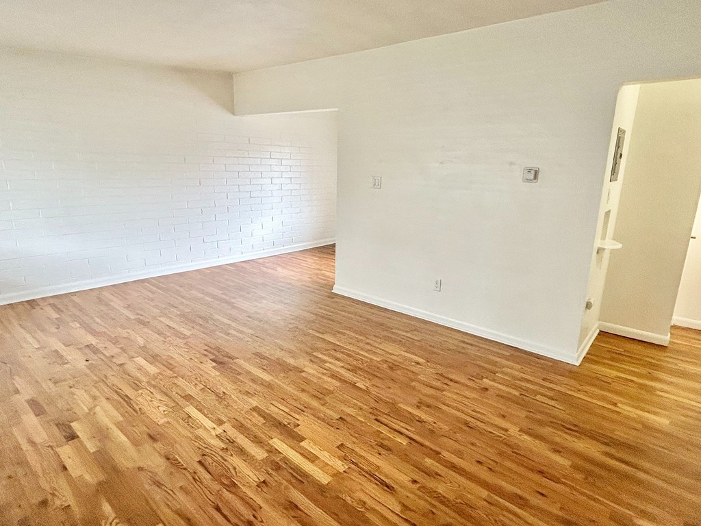 A room with wooden flooring and white walls.