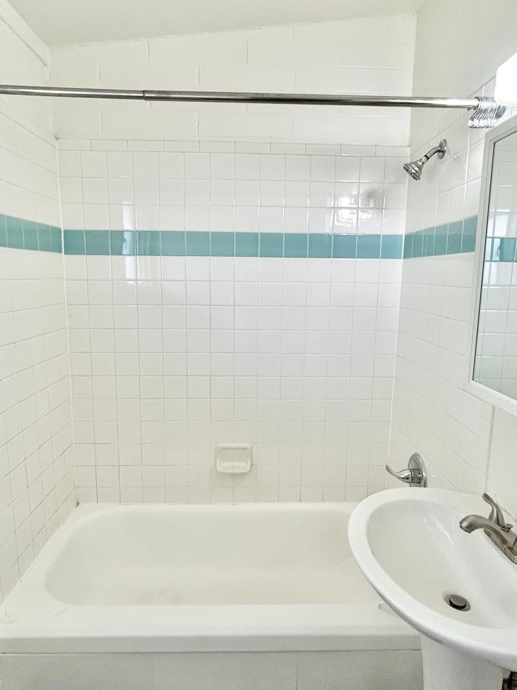 A white bathroom with a white tub and sink.