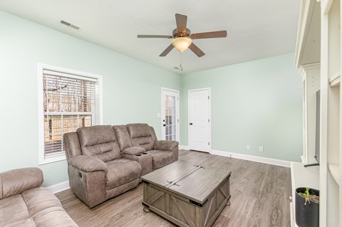 A living room with a brown leather couch and a brown coffee table.
