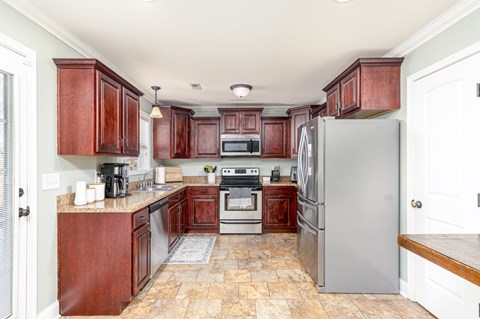 A kitchen with wooden cabinets and a tile floor.
