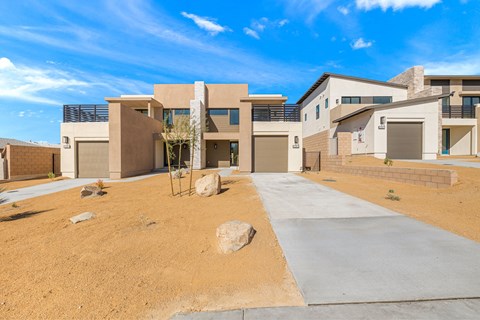 A modern house with a concrete driveway in front.