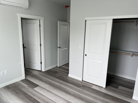 A room with white doors and a wooden floor.