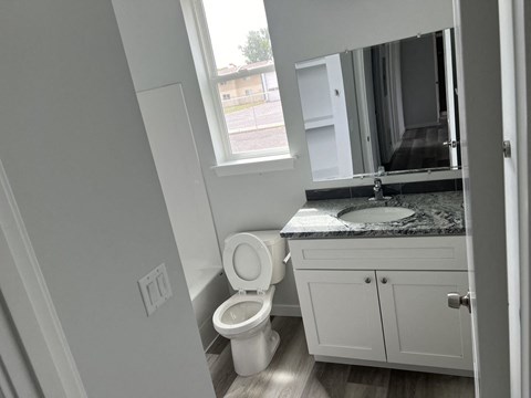 A bathroom with a toilet, sink, and cabinet.
