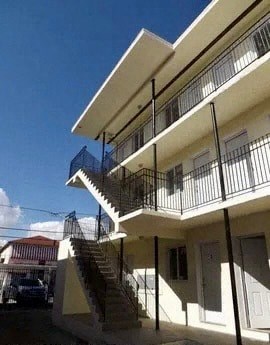 A white building with a balcony and stairs.