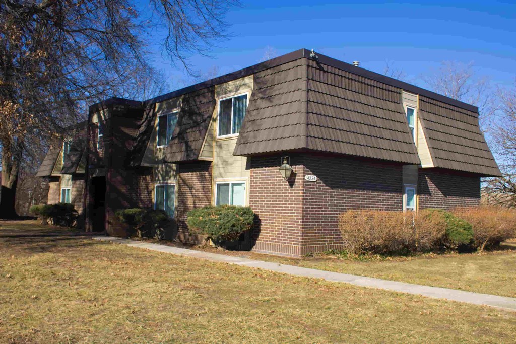 A house with a brown roof and a white sign on it.