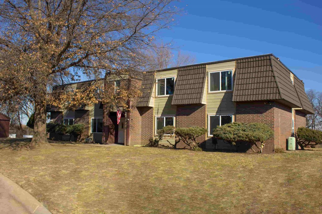 Apartment building with a brown roof and a flag on the front.