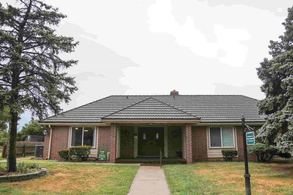 A house with a green door and a sign in front.
