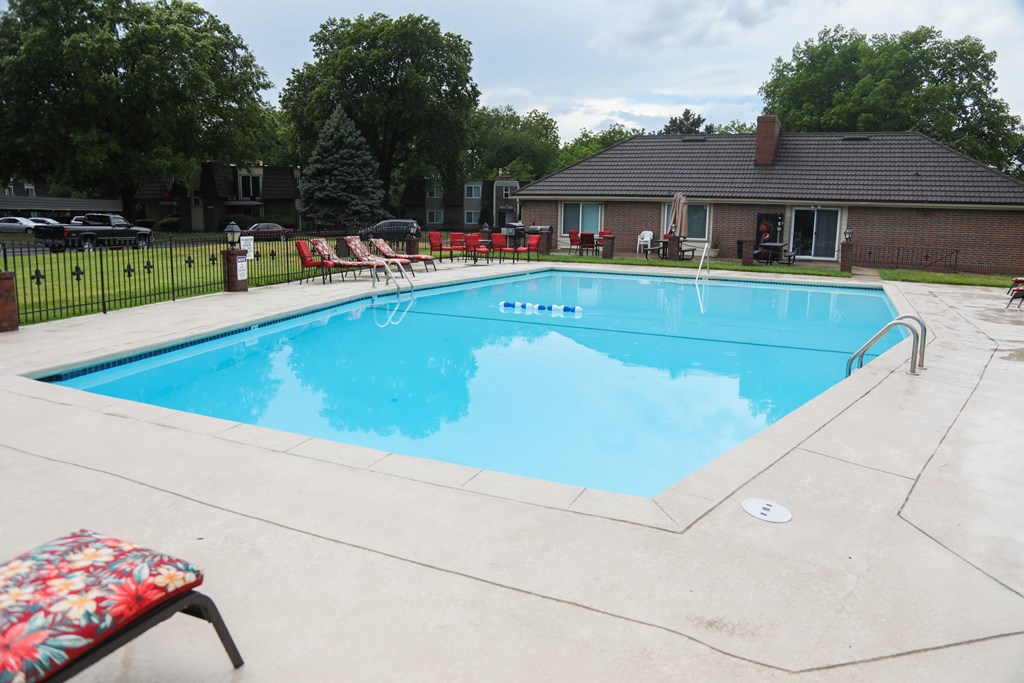 A pool with a bench and a table in front of it.