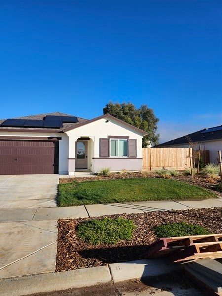 A house with a brown garage door and solar panels on the roof.