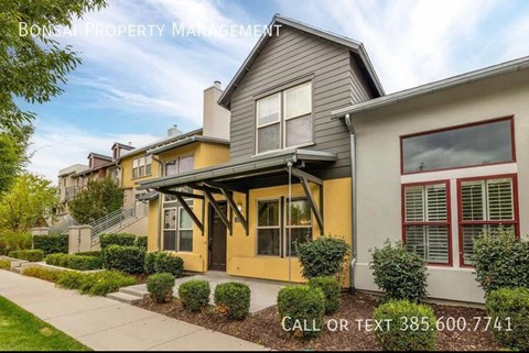 A row of houses with a sign that says "BONS PROPERTY MANAGEMENT" and a phone number.