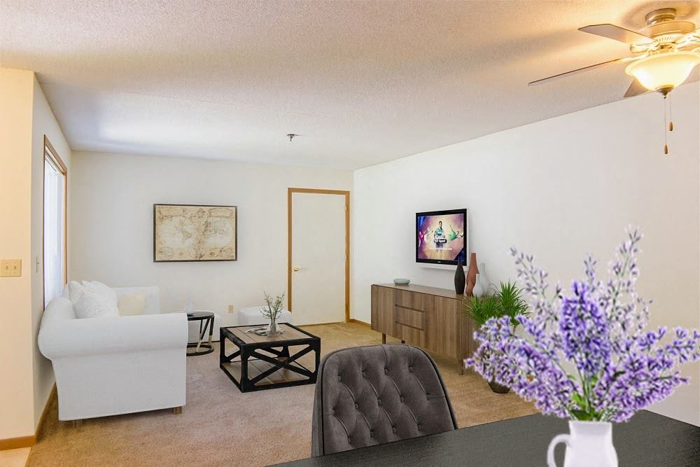 A living room with a white couch, a black coffee table, and a painting on the wall.