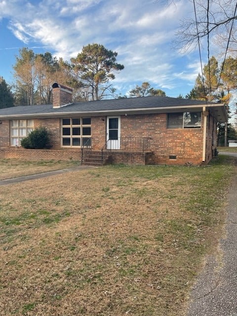 A small brick house with a white door and a small porch.