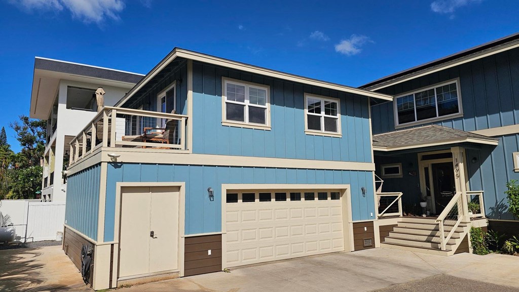 A blue house with a white garage door.