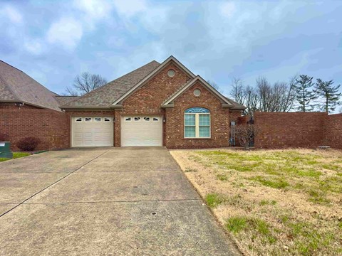 A brick house with a garage and a driveway.