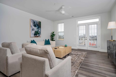A living room with a large painting on the wall and a ceiling fan.